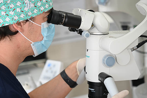 Dentista realizando endodoncia microscópica